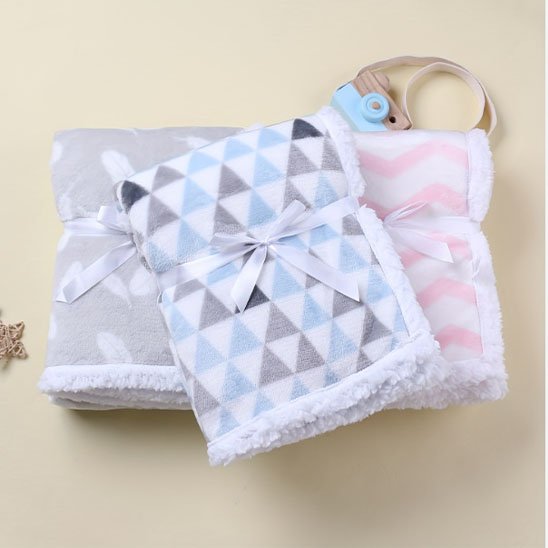 Couverture bébé avec trois couvertures pliées avec ruban satiné, motifs triangles chevrons plumes
