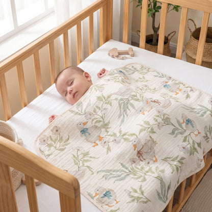 Couverture bébé en gaze motif canetons recouvrant un bébé endormi