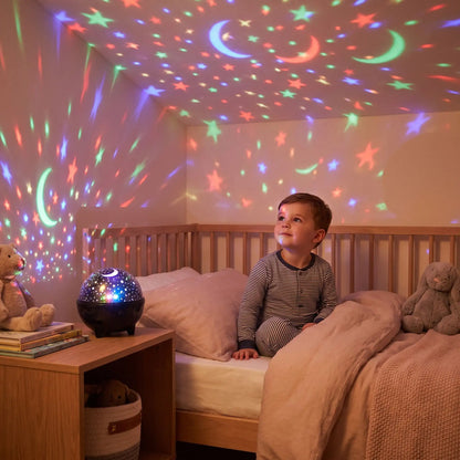 Veilleuse projection d'étoiles et de lunes, jeune garçon émerveillé contemplant le plafond illuminé