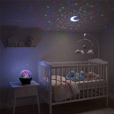 Veilleuse projection diffusant des motifs colorés au-dessus d'un bébé endormi