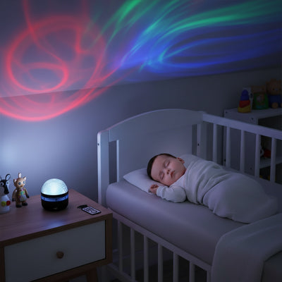 Veilleuse projection rouge bleue illuminant le plafond pendant le sommeil du bébé
