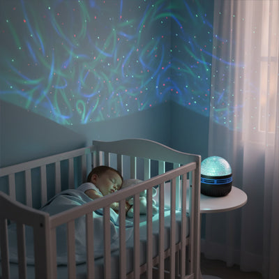 Veilleuse projection verte bleue illuminant la chambre pendant le sommeil du bébé
