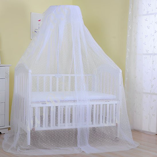 Ciel de lit bébé blanc enveloppant un berceau en bois