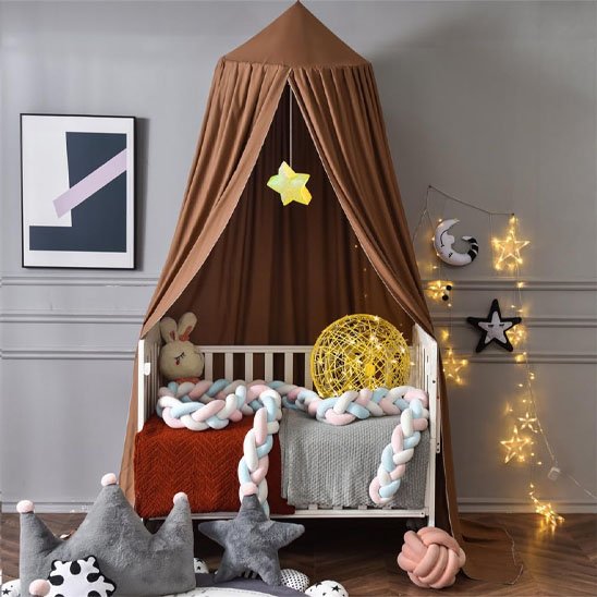 Ciel de lit bébé marron au-dessus d'un berceau avec tresse et guirlandes