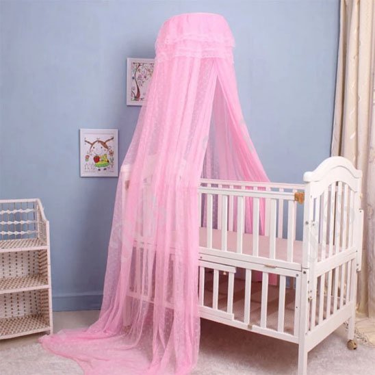 Ciel de lit bébé rose en dentelle sur berceau blanc