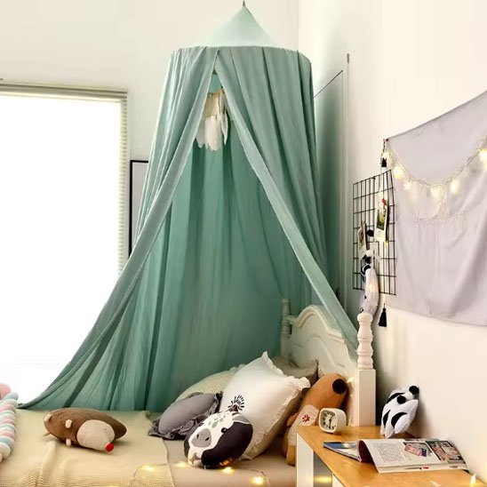 Ciel de lit bébé vert d'eau au-dessus d'un lit blanc, plumes suspendues
