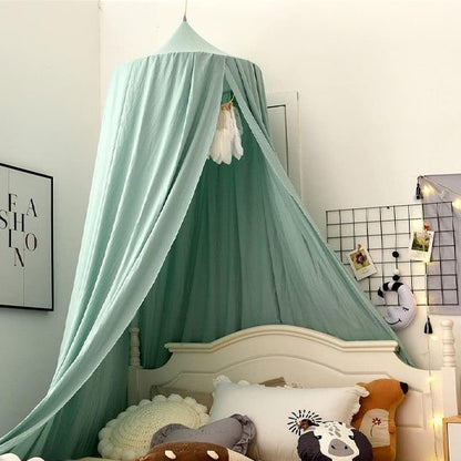 Ciel de lit bébé vert d'eau avec lit blanc et coussins et guirlande lumineuse