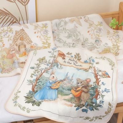 Couverture bébé motifs contes de fées posée sur un lit