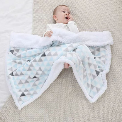 Couverture bébé triangles colorés dépliée avec nourrisson bébé allongé bras écartés
