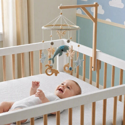 Mobile bébé thème océan avec nourrisson souriant allongé dans un lit blanc
