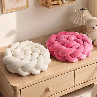 Tour de lit tressé assorti couleur beige et rose  posée sur commode