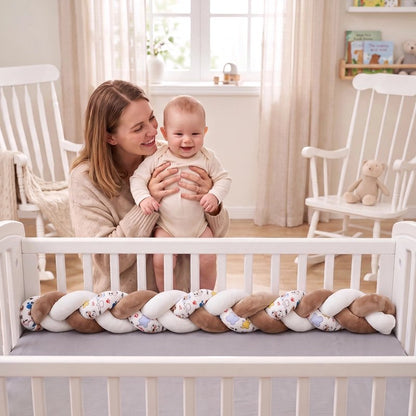 Tresse de lit marron et blanche sur berceau blanc avec maman tenant son enfant