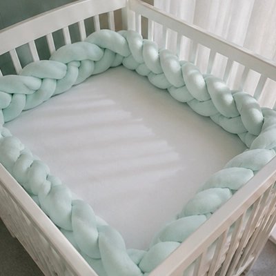 Tresse de lit verte protégeant tout le tour d'un lit bébé vide